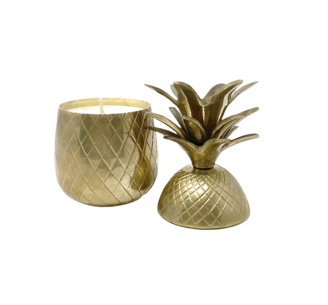 Gold pineapple-shaped candle holder with a candle inside on a white background