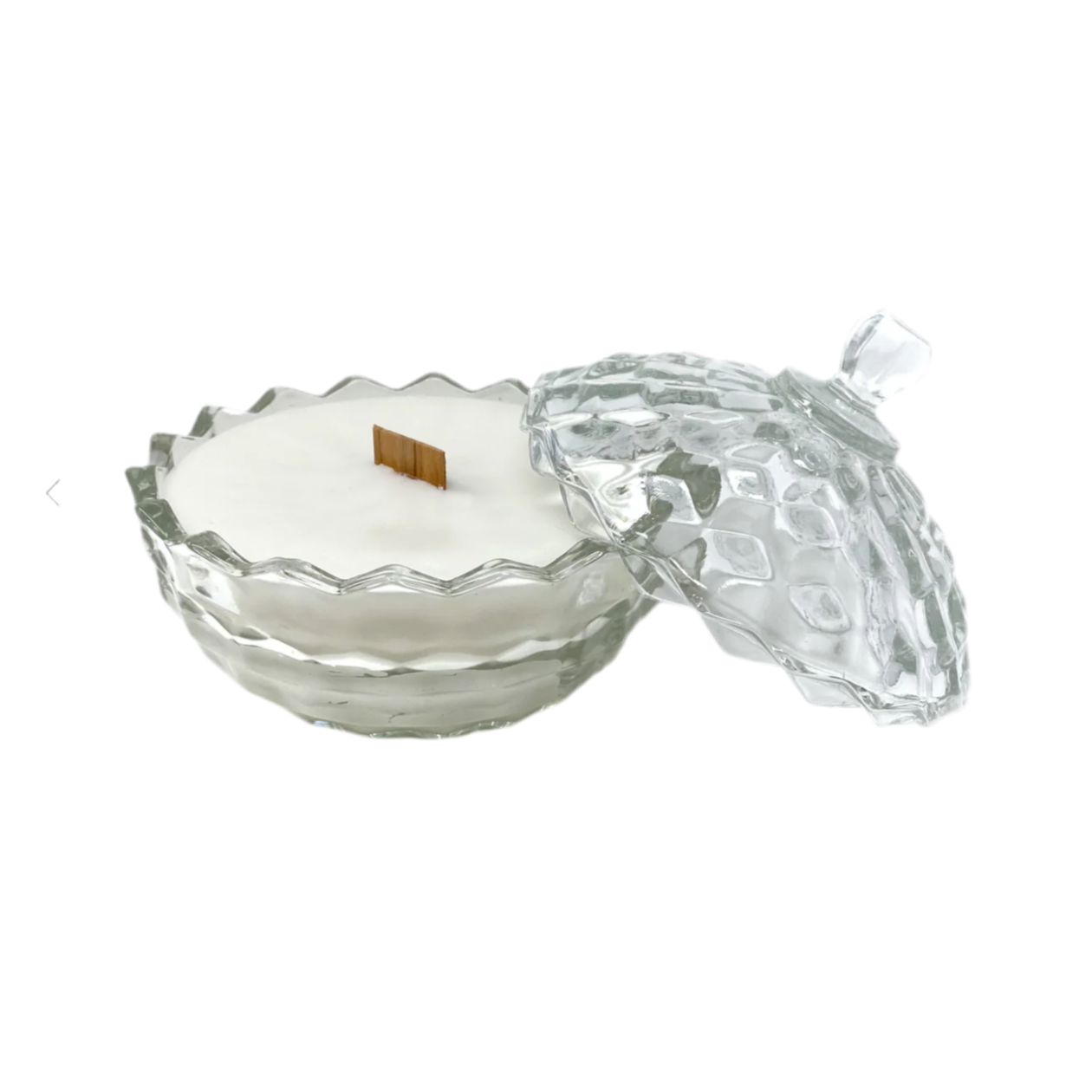 Glass candle holder with a white candle inside on a white background
